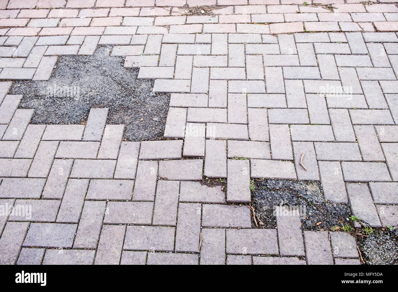 Scarsa e irregolare e riparazione utilizzando l'asfalto a un marciapiede costruito dal blocco pavimentazione, Nottingham, Inghilterra, Regno Unito Foto Stock