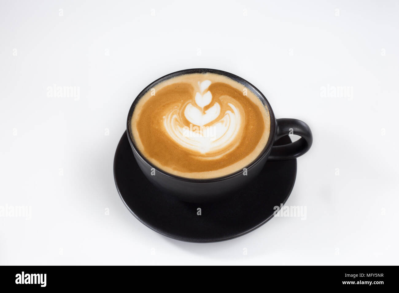 Una tazza di caffè latee sulla tazza nera in sfondo bianco isolare Foto Stock
