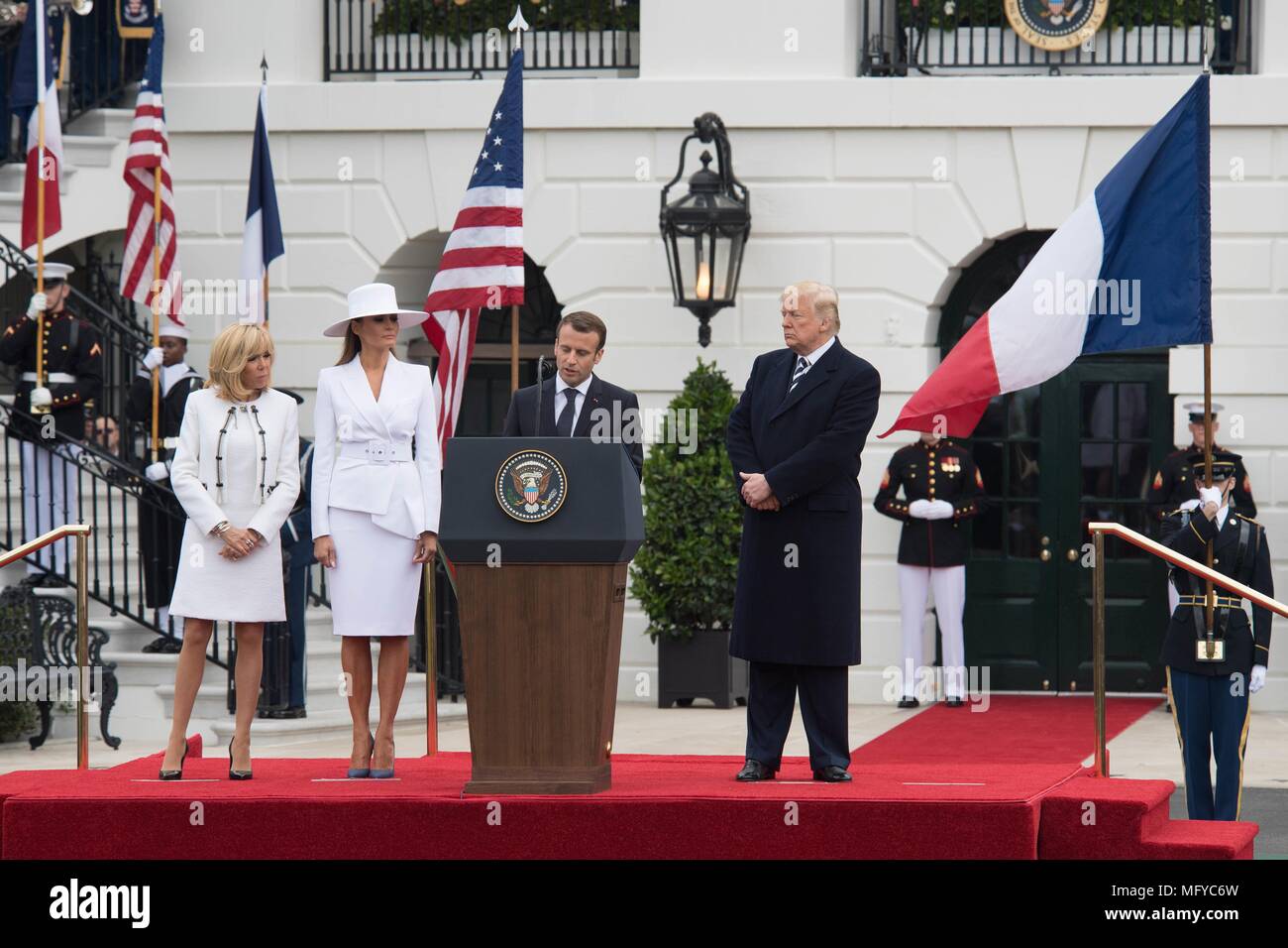 U.S presidente Donald Trump, a destra il presidente francese Emmanuel Macron, First Lady Melania Trump e Brigitte Macron, sinistra, stand durante la solenne cerimonia di arrivo sul prato Sud della Casa Bianca Aprile 24, 2018 a Washington, DC. Macron è in visita di Stato a Washington la prima dal Presidente Trump ha preso l'ufficio. Foto Stock