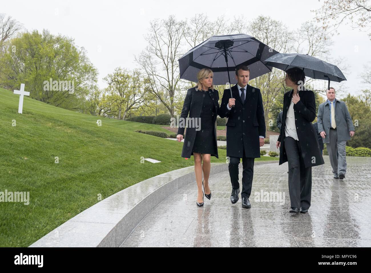Il Presidente francese Emmanuel Macron, centro e da sua moglie Brigitte Macron, sono scortati dalla soprintendente Katharine Kelley, destra durante una visita al recinto di Robert F. Kennedy in un giorno di pioggia al Cimitero Nazionale di Arlington, Aprile 24, 2018 in Arlington, Virginia. Foto Stock