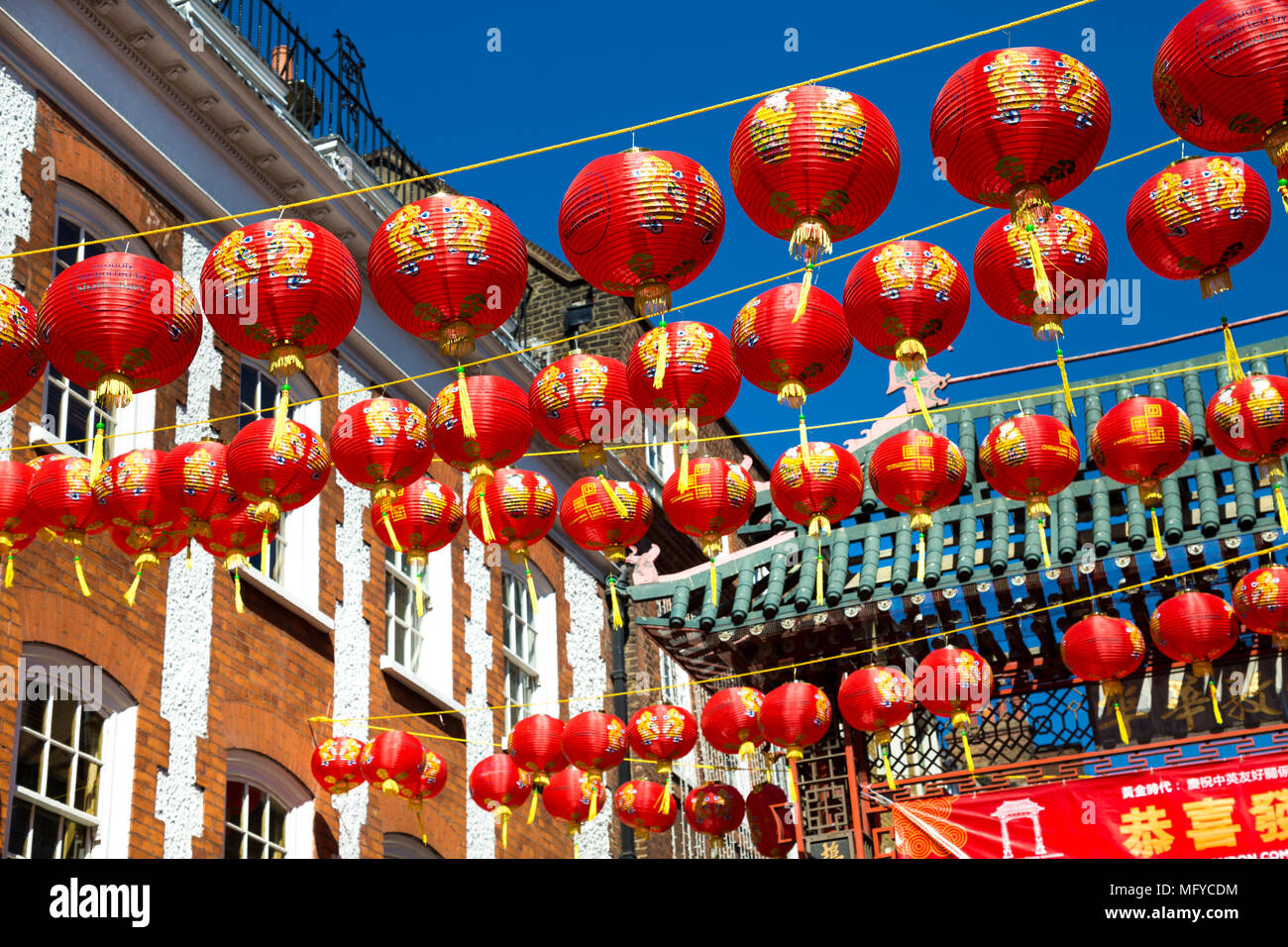 Rosso e giallo lanterne cinesi appeso sopra una strada in China Town, Londra, Regno Unito Foto Stock