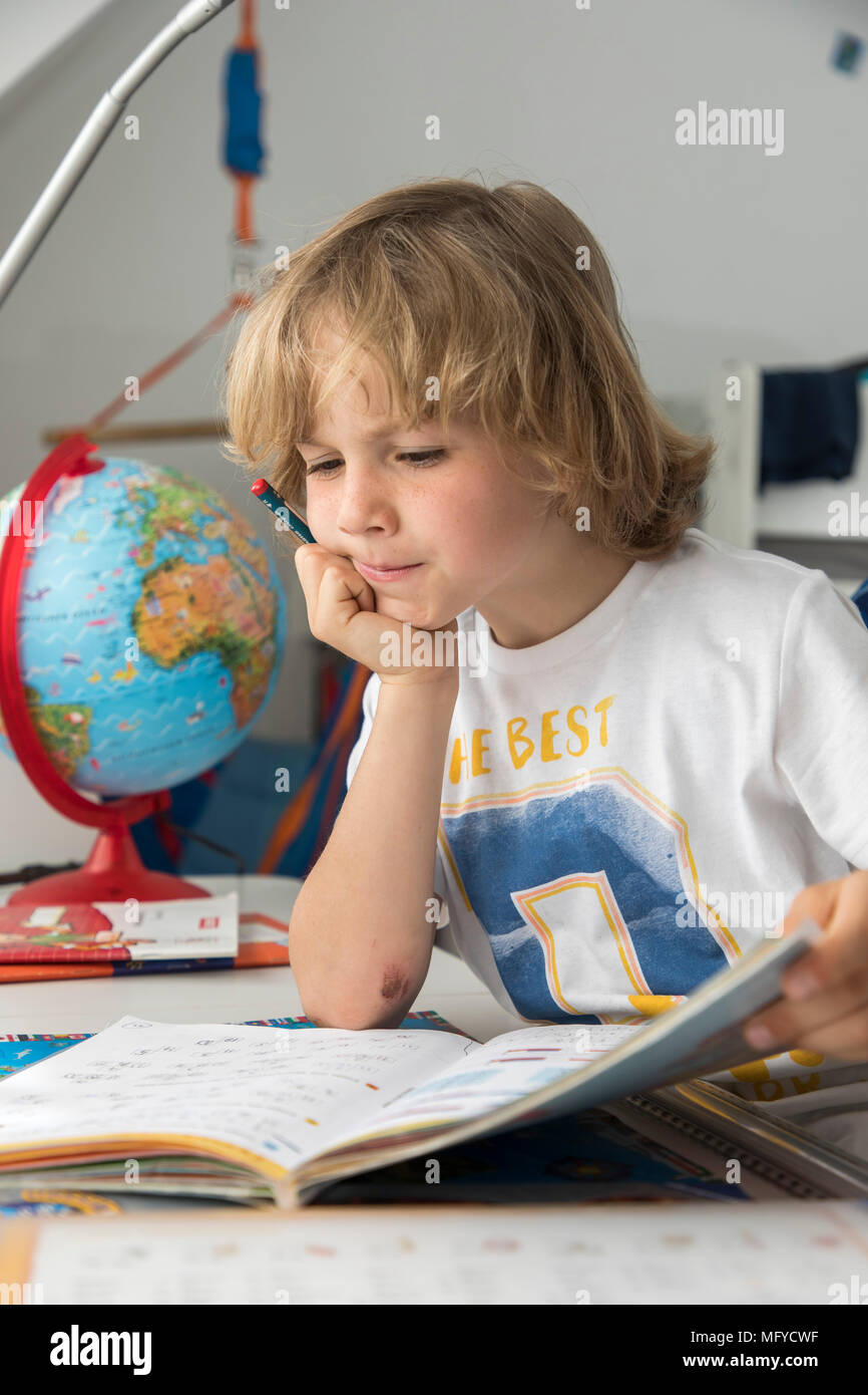 Il ragazzo, scuola elementare studente, 8 anni, impara a scuola a casa, non i compiti, matematica, Foto Stock