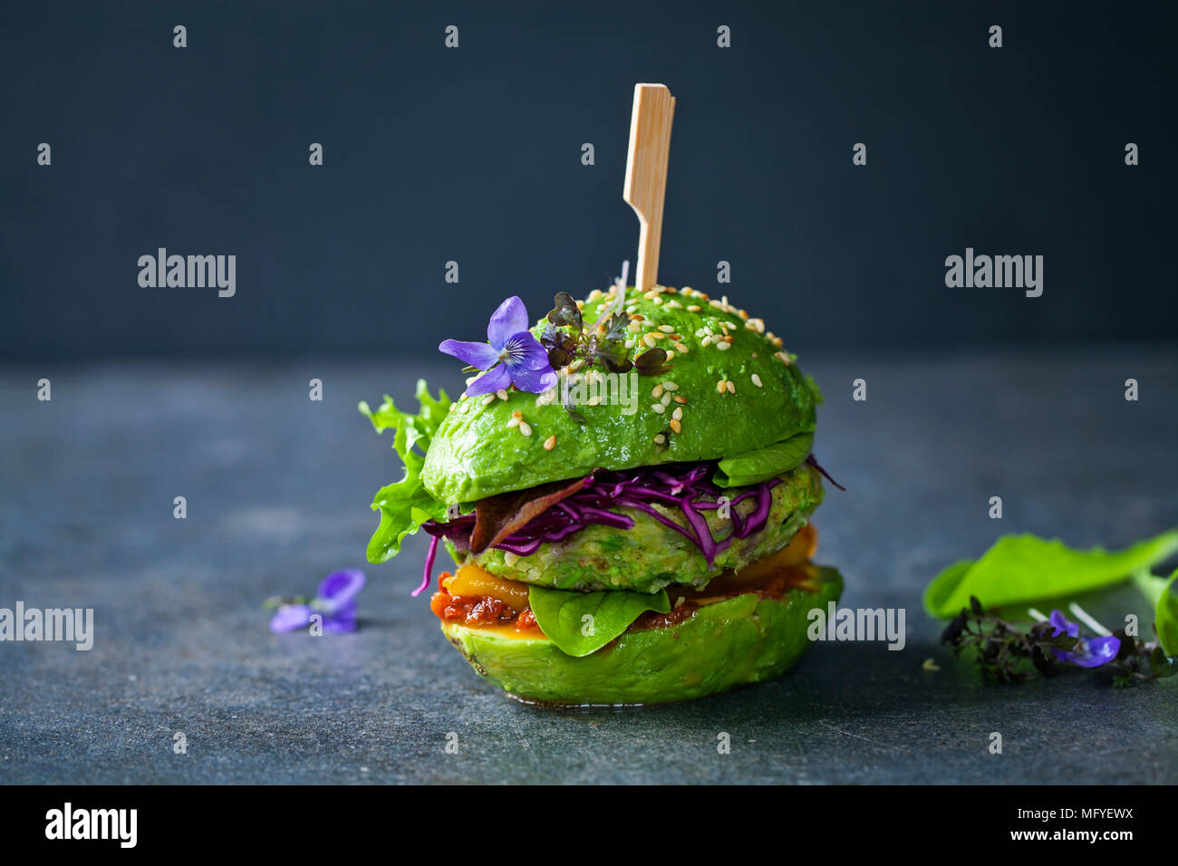 Sandwich di Avocado con green vegan burger, arrosto di peperone giallo e decapati cavolo rosso Foto Stock