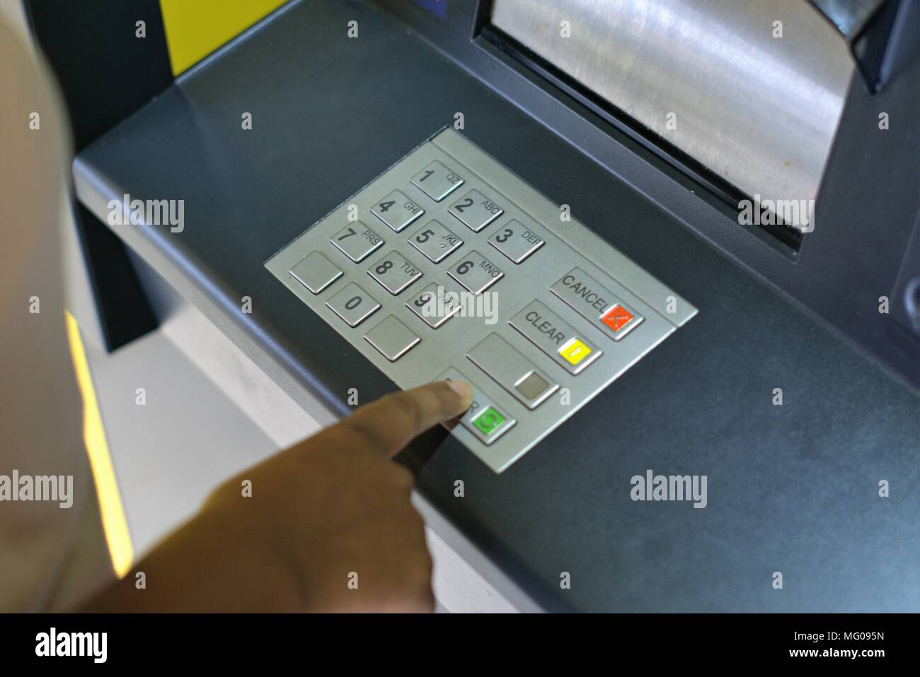 Persona che utilizza ATM. Immagine della mano della persona premendo tasti numerici per immettere il codice pin per il bancomat. Concetto di sicurezza finanziaria, furti, frodi bancarie Foto Stock