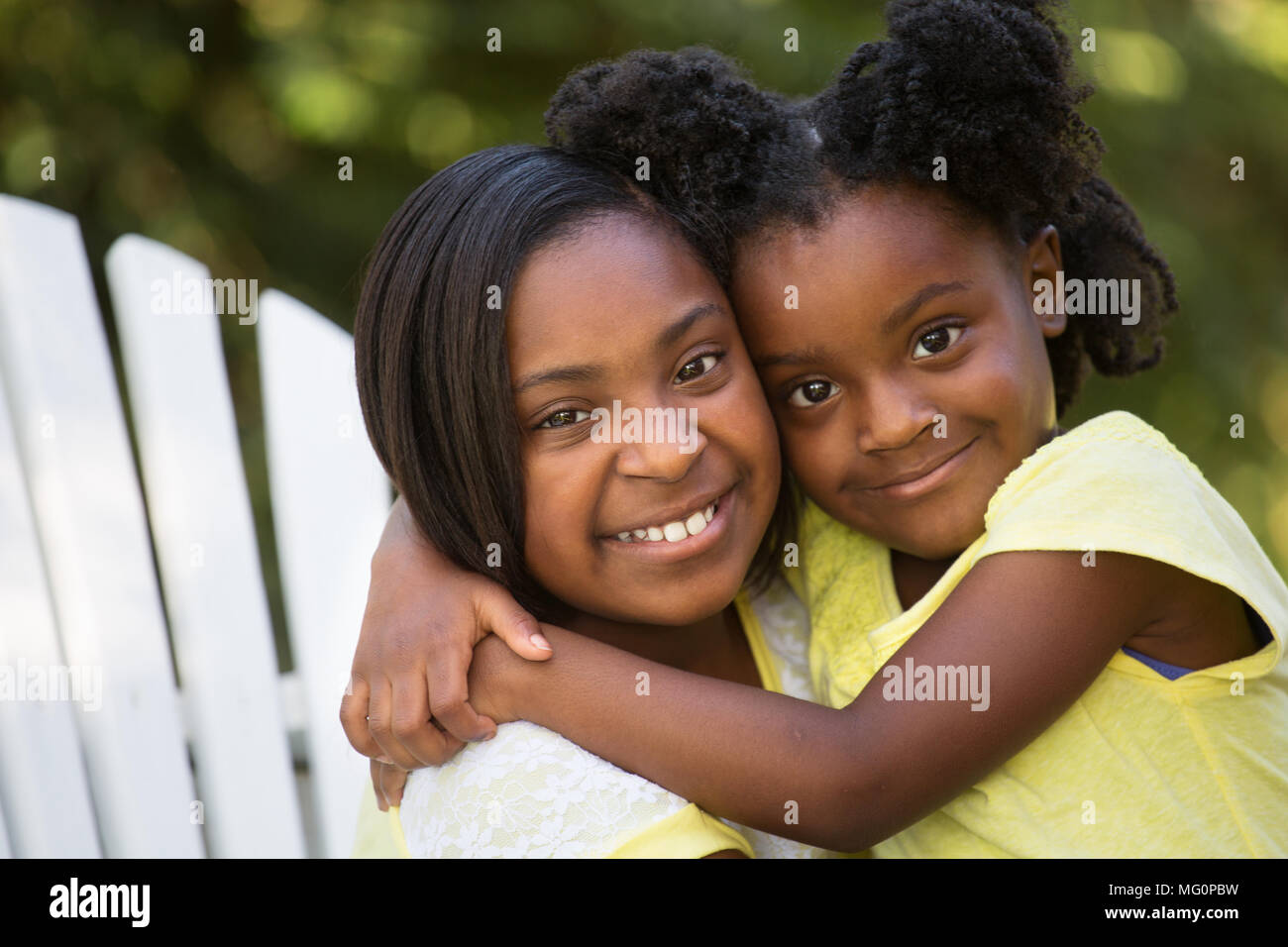 Due sorelle abbracciando all'esterno. Foto Stock