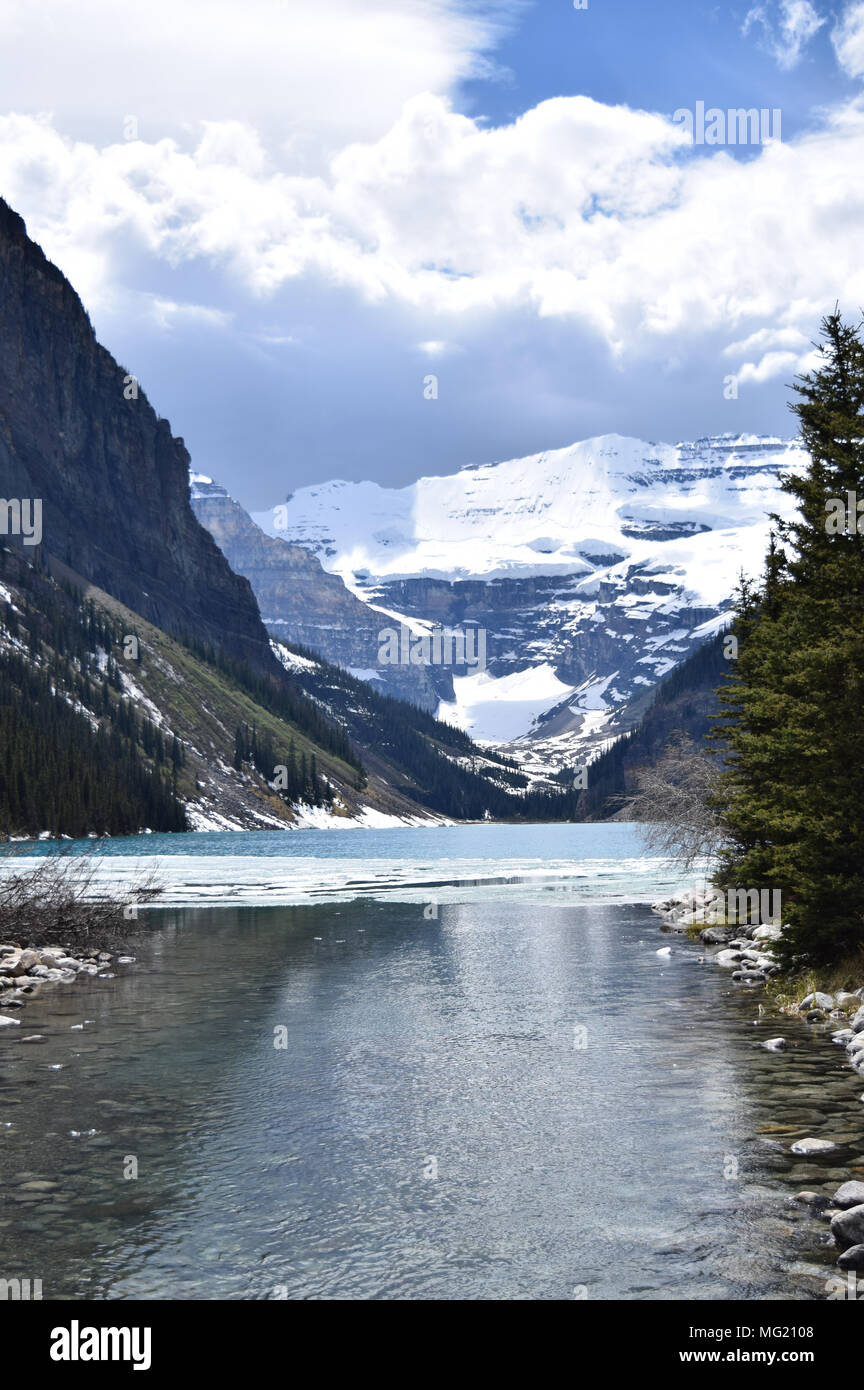 Le maestose Montagne Rocciose Canadesi torre sopra le splendide acque del Lago Louise, Alberta su una tarda primavera. Foto Stock