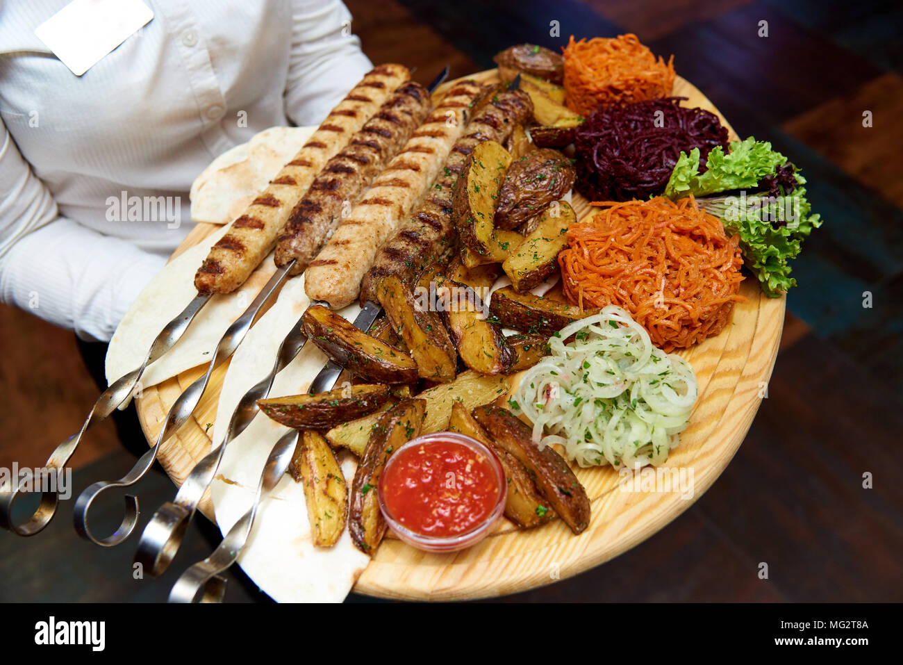 Snack alla birra su una tavola di legno nelle mani di un cameriere Foto Stock