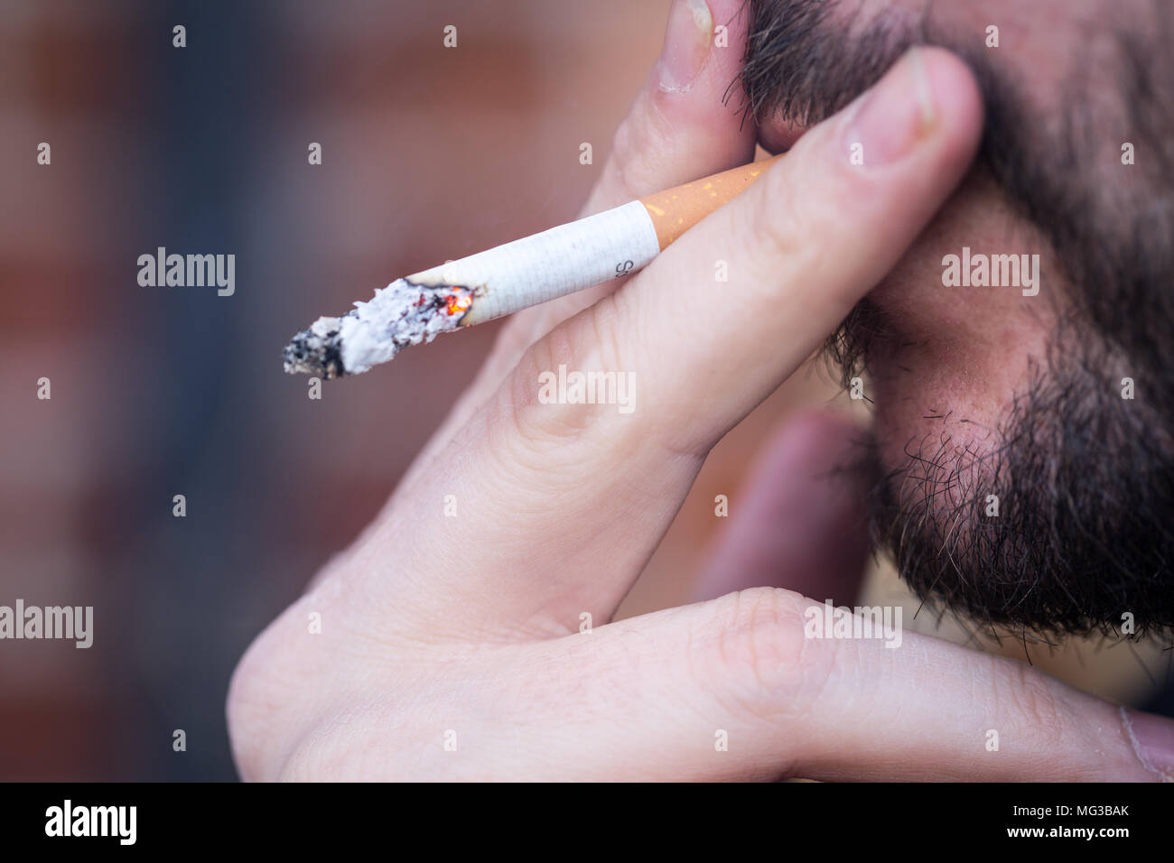 Fumatori, uomo inalazione di una sigaretta, close up Foto Stock
