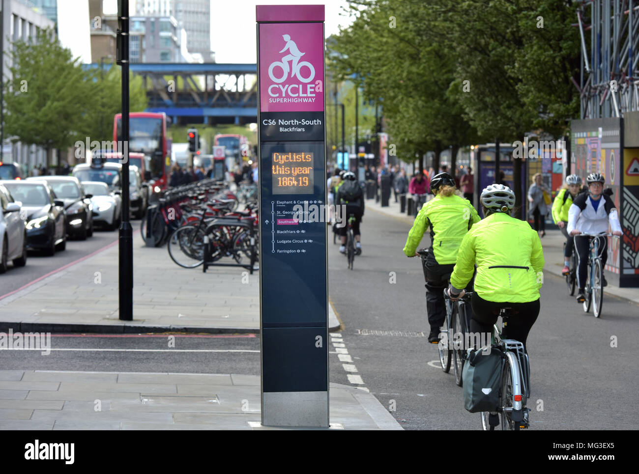 Le donne i ciclisti ride passato il superhighway di contatore di bicicletta come loro capo sud lungo la CS6 bike lane su Blackfrairs Road nel centro di Londra durante il Foto Stock
