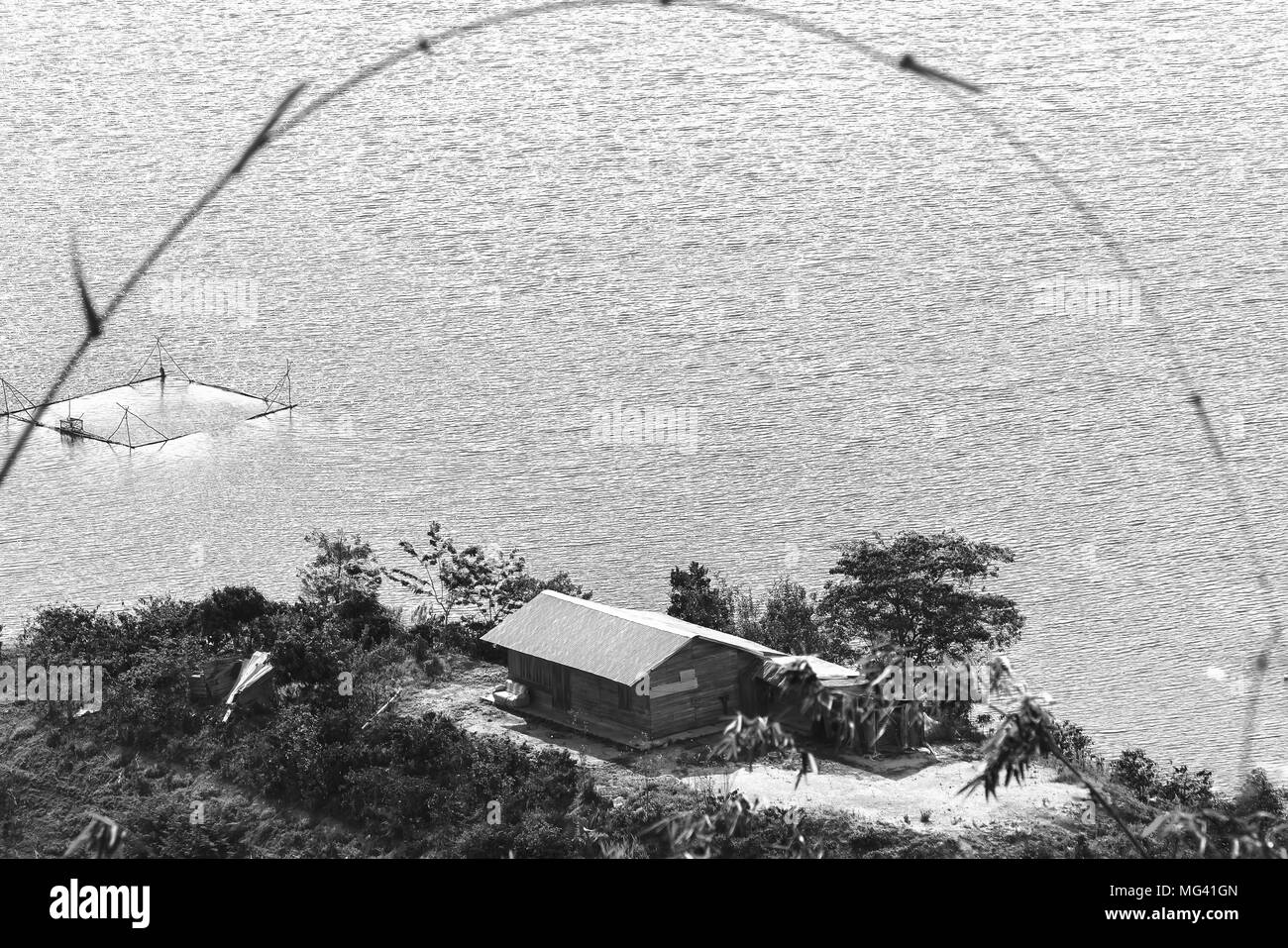 Piccola casa sotto l'isola in un grande lago è pacifica nel pomeriggio di estate. Foto Stock