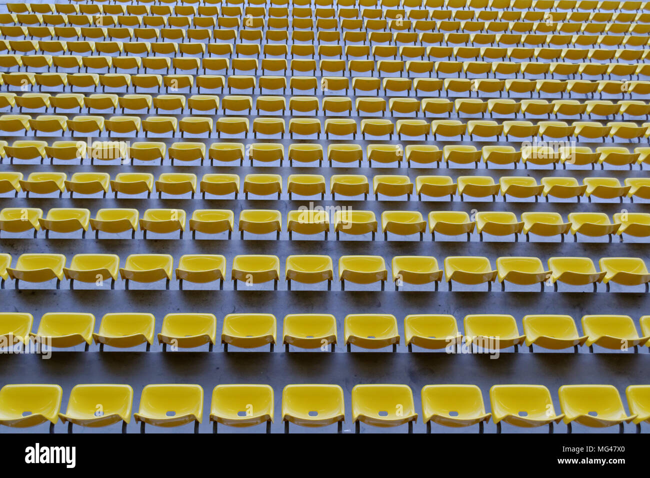 Fila di sedili di colore giallo in un arena di calcio Foto Stock
