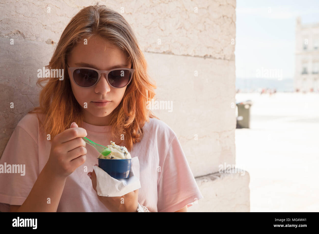 Europeo teenage girl in occhiali da sole mangia gelato, close up ritratto all'aperto Foto Stock