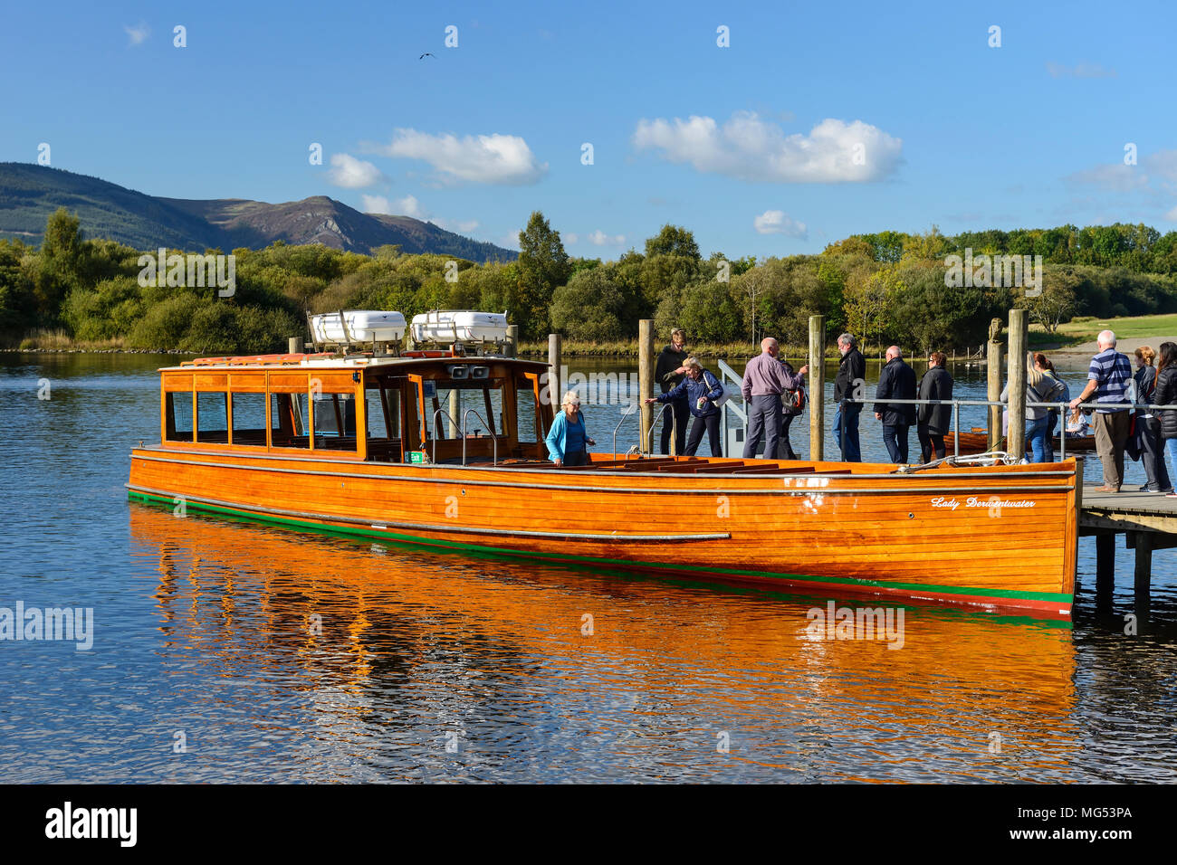 I turisti di salire a bordo del Lady Derwentwater lancia a motore a Keswick imbarcadero sulla Derwent Water nel Parco Nazionale del Distretto dei Laghi, Cumbria, Inghilterra Foto Stock