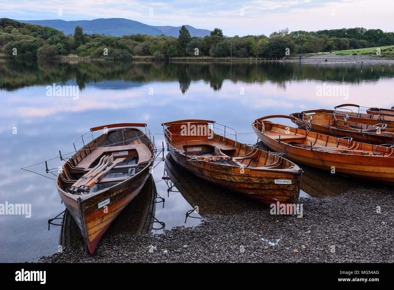 In legno barche a remi in riva a Keswick imbarcadero all'alba sulla Derwent Water nel Parco Nazionale del Distretto dei Laghi, Cumbria, Inghilterra Foto Stock