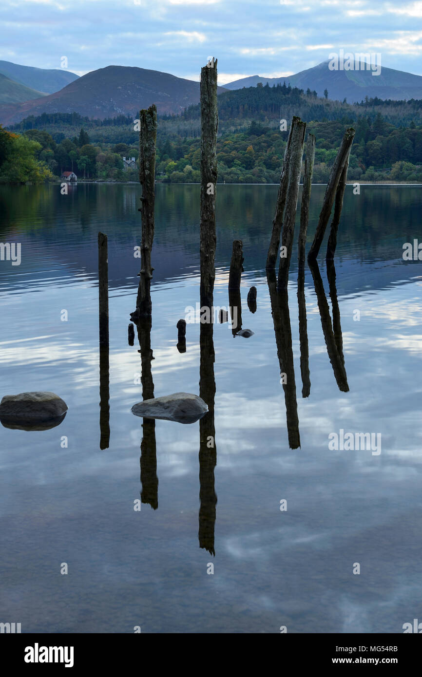 Resti di un antico molo riflessa nella Derwent Water nel Parco nazionale del Lake District in Cumbria, Inghilterra Foto Stock