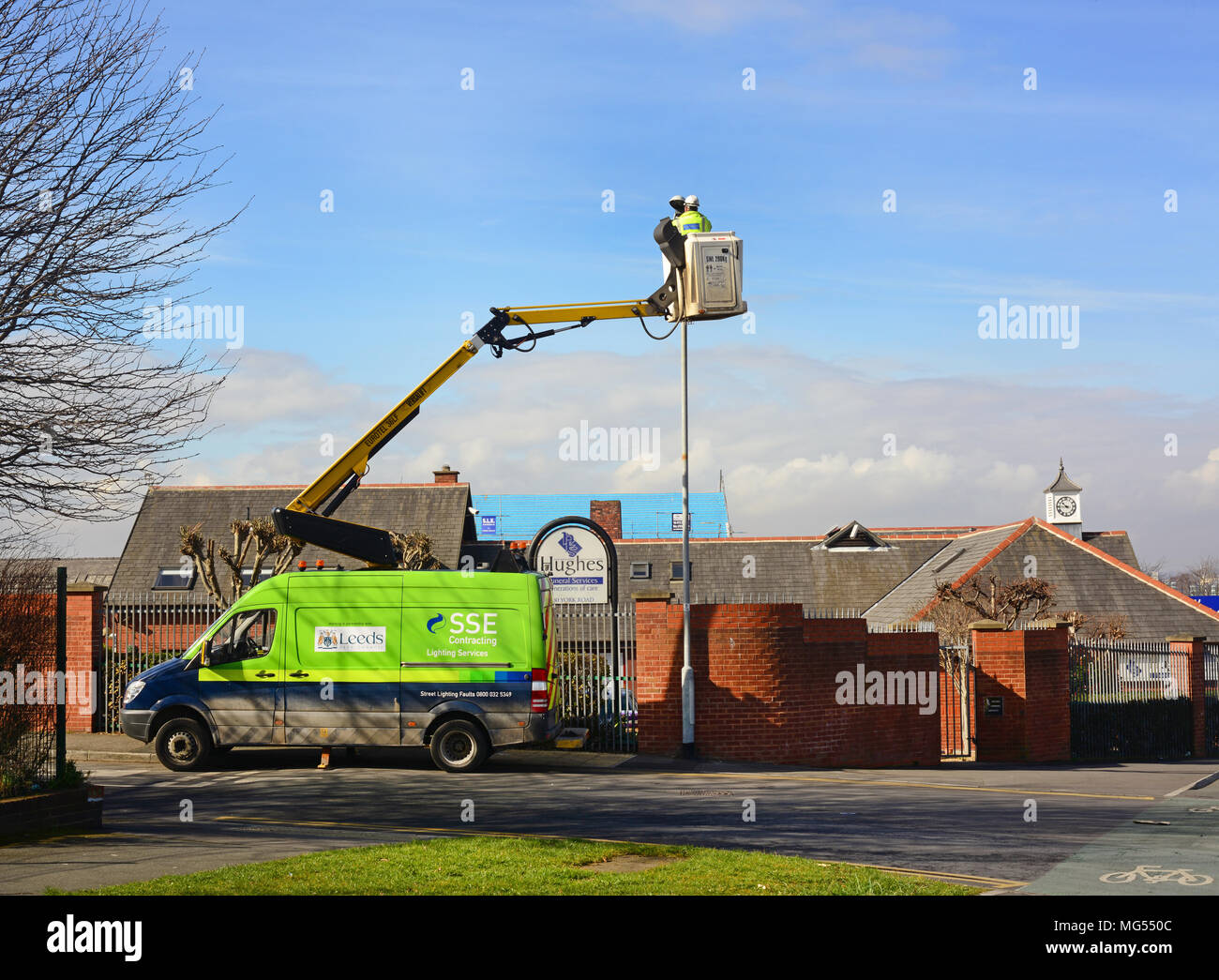 Lavoratore di manutenzione utilizzando cherry picker per sostituire la lampadina in streelight leeds Yorkshire Regno Unito Foto Stock