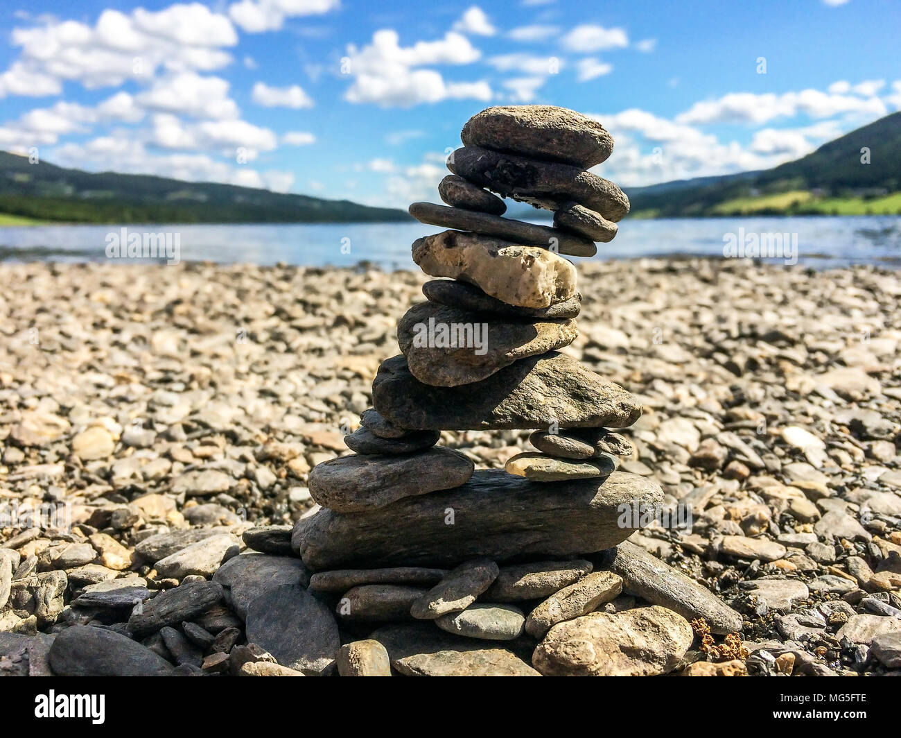 Piccole pietre impilate come una torre di pietra che può simboleggiare l'equilibrio, la pazienza e la maestria. Foto Stock