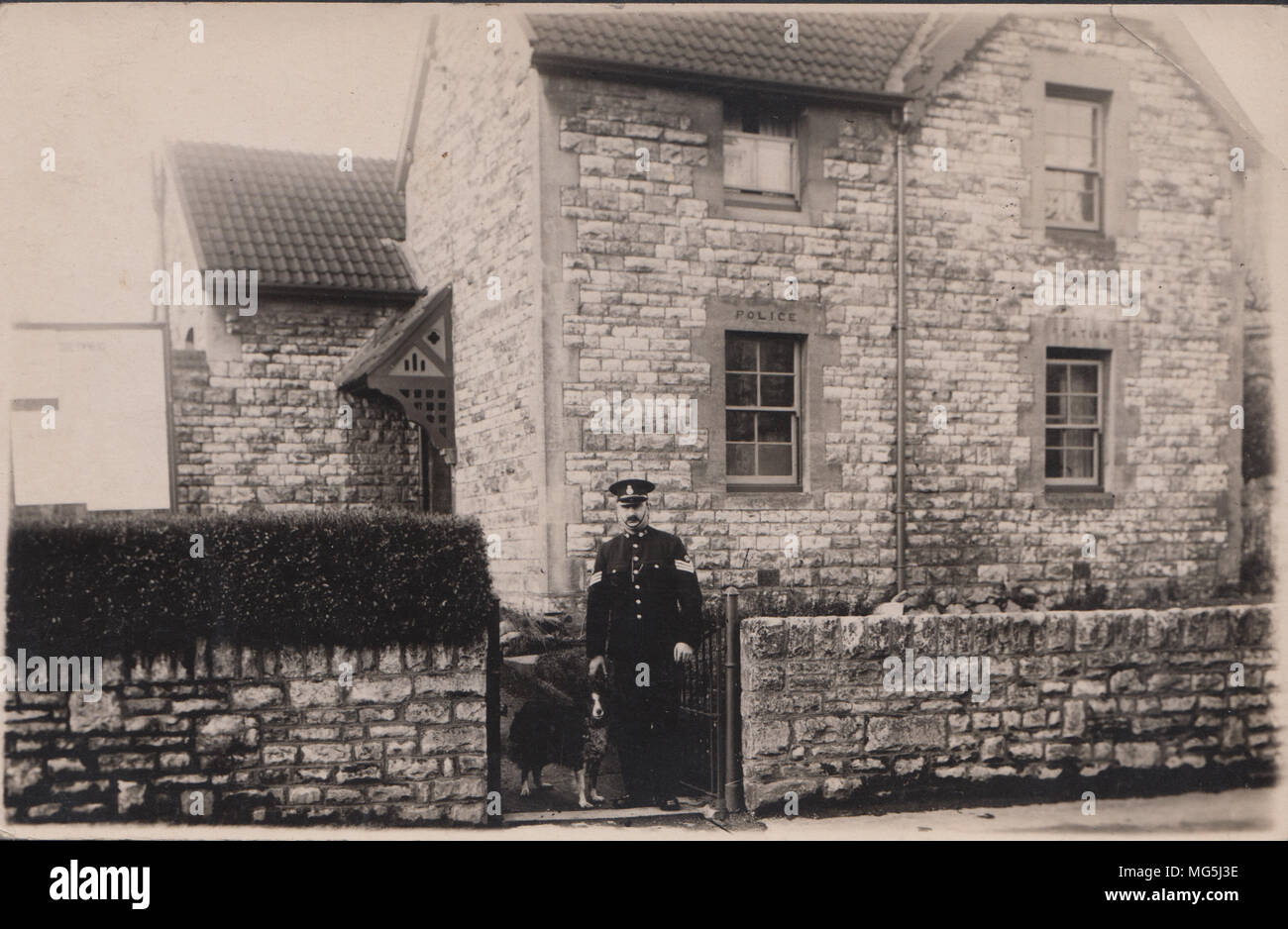 Vera Cartolina fotografica di una polizia britannica stazione. Jim e di Bessie il cane al cancello Foto Stock