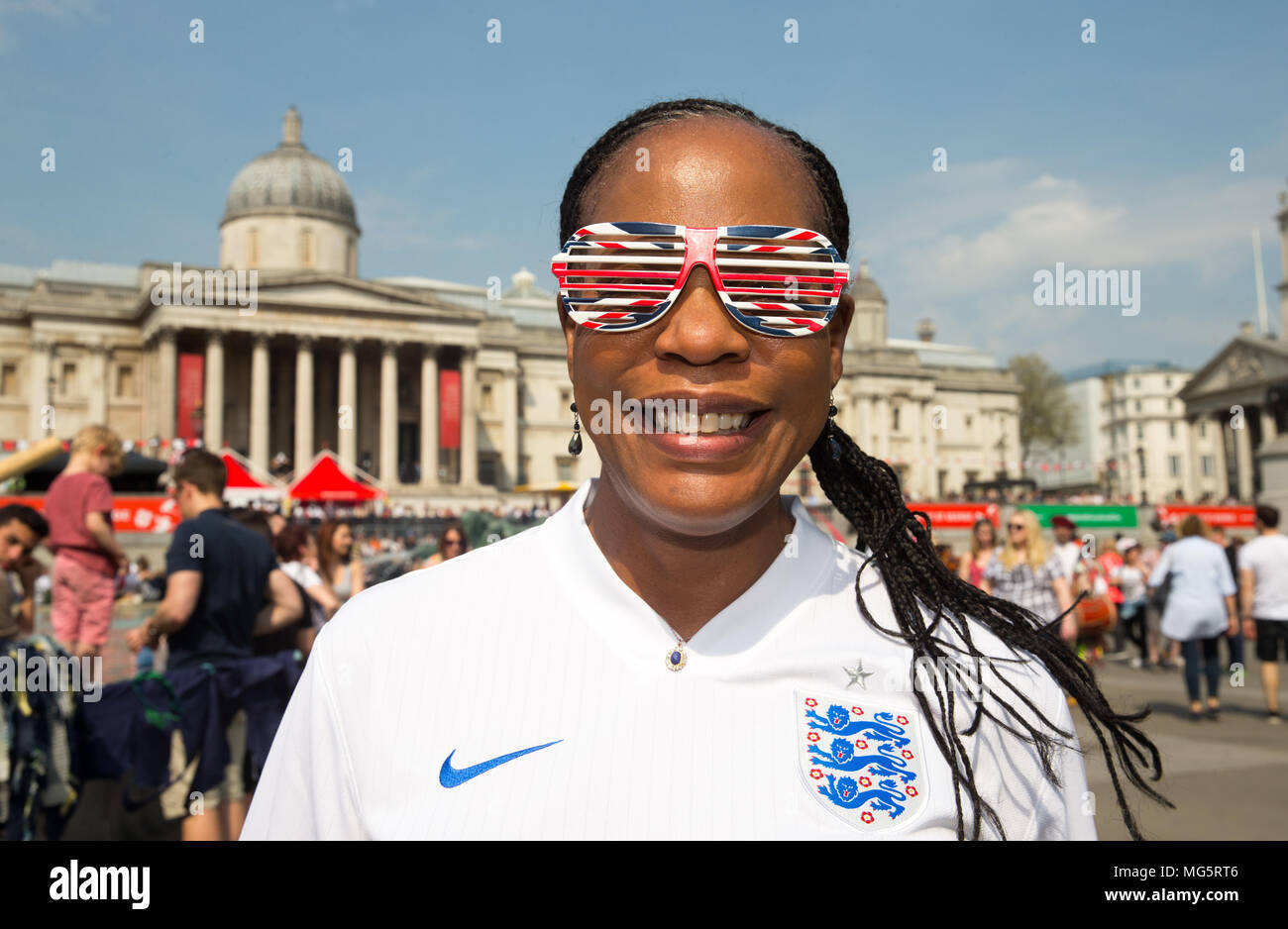 Una donna con una maglietta in Inghilterra e Unione Jack occhiali da sole si unisce a celebrazioni in Trafalgar Square per la festa di San Giorgio" di Mark St George's Day. Foto Stock