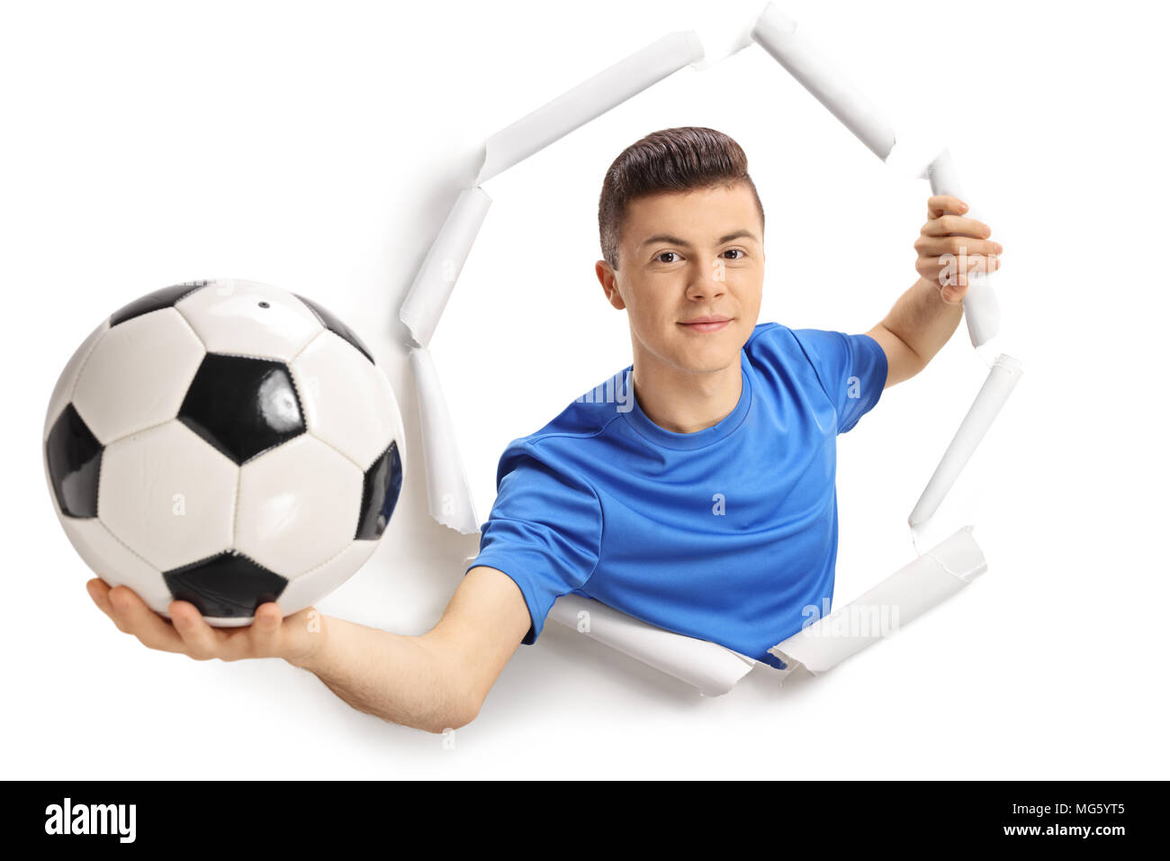 Teenage giocatore di calcio che mostra un campo di calcio e di rottura attraverso la carta Foto Stock