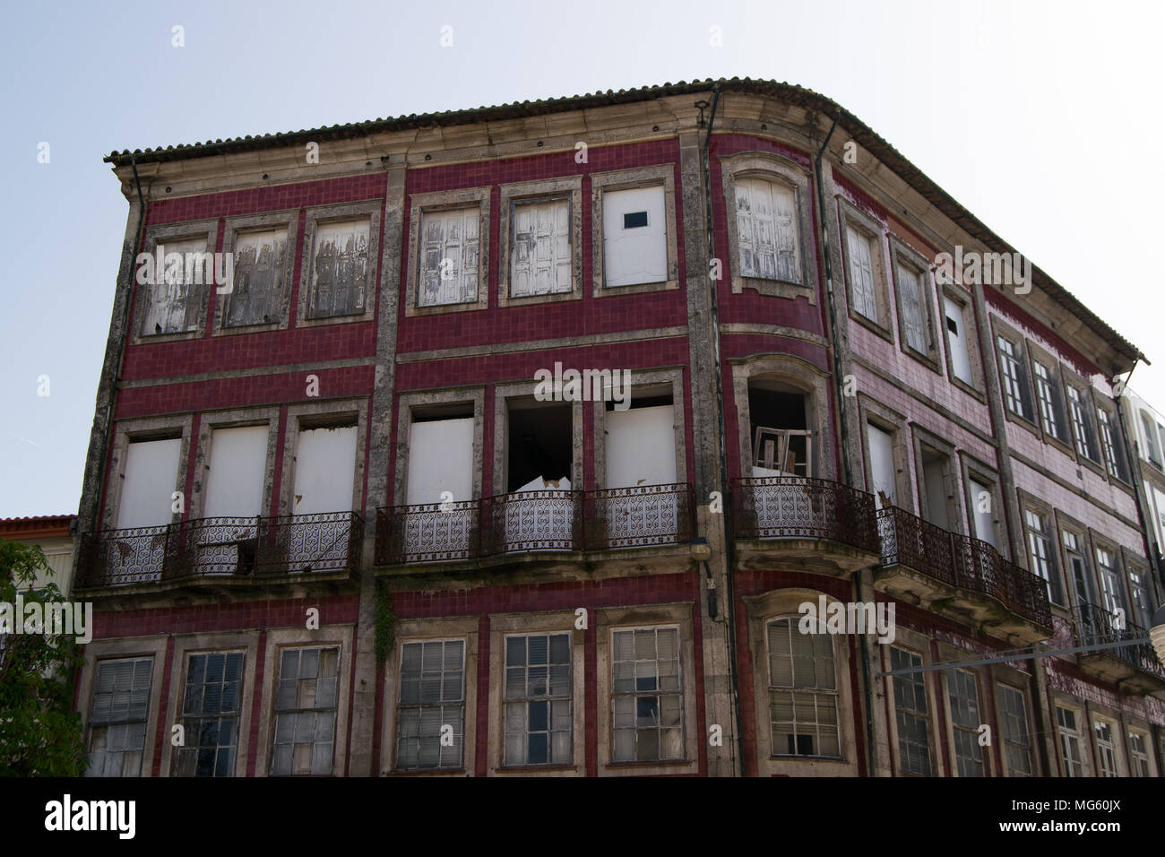 Vecchio edificio abbandonato con facciata in vernice rossa a Braga Portugal Foto Stock