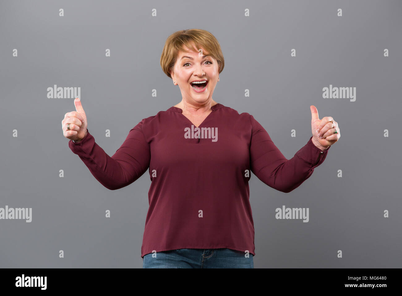 Felice bella donna che mostra segni OK Foto Stock