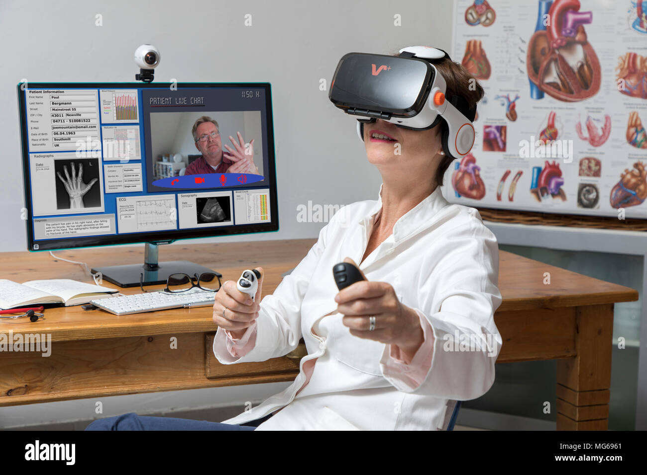Foto simbolico della telemedicina, un medico di sesso femminile in un ambulatorio medico, con occhiali VR, realtà virtuale, 3-D la visualizzazione di un report di MRI, comunica wit Foto Stock