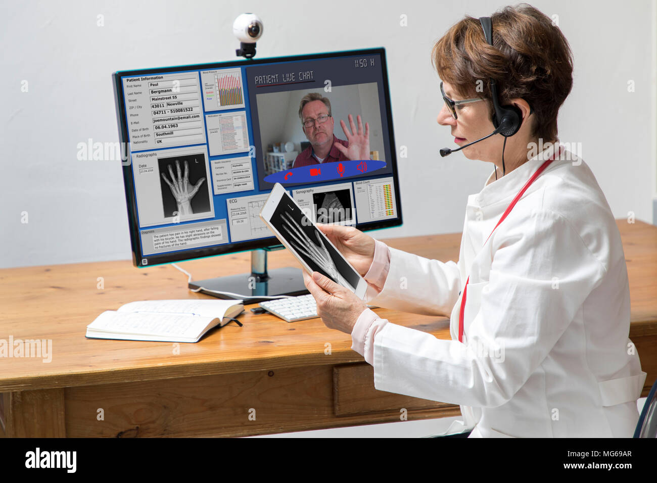 Foto simbolico di telemedicina, un medico in un ambulatorio medico, comunica con il paziente attraverso una webcam, i dati del paziente e le risultanze sul monitor, Foto Stock