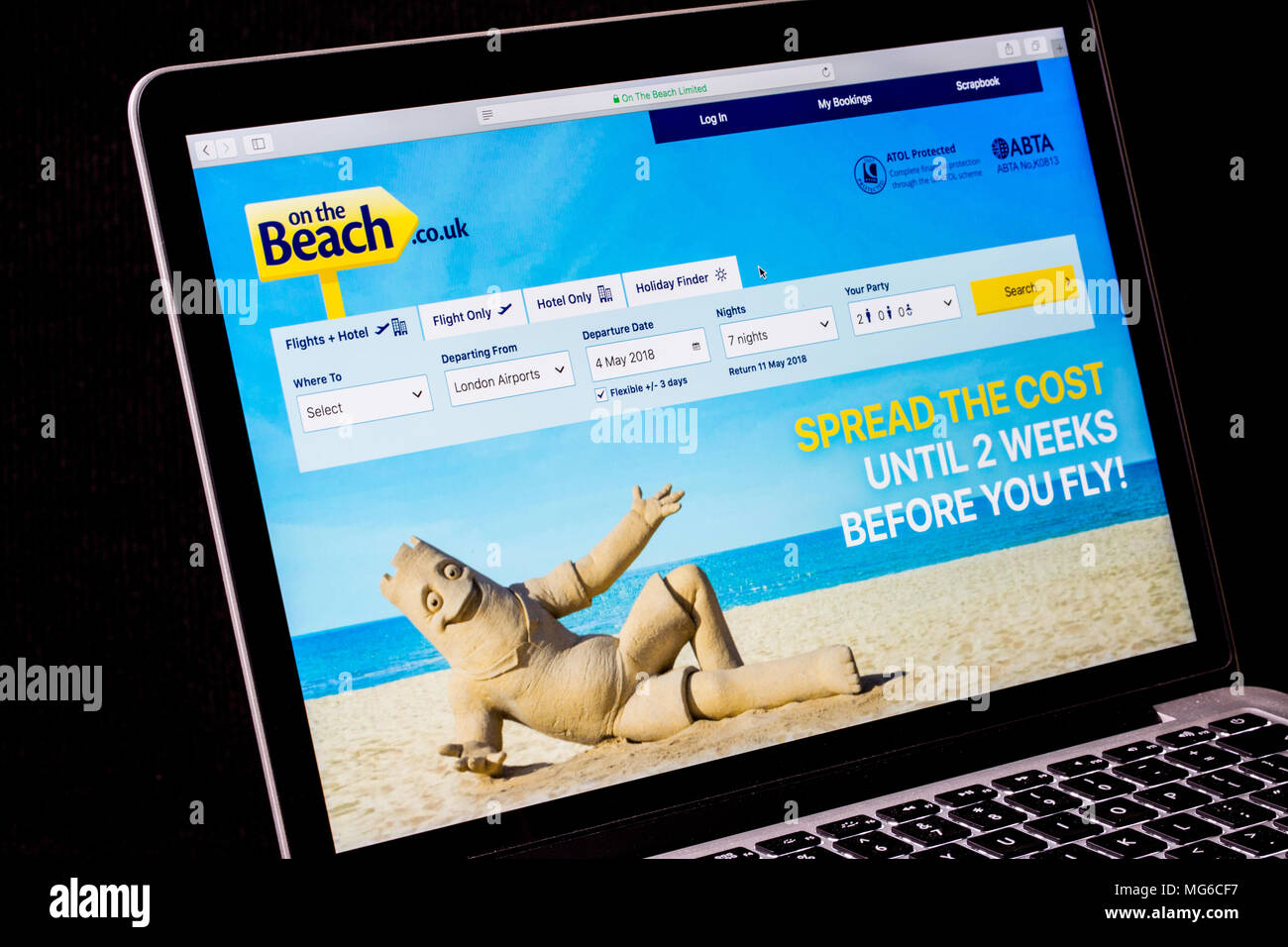Sulla spiaggia sito web di viaggio su un computer portatile Foto Stock