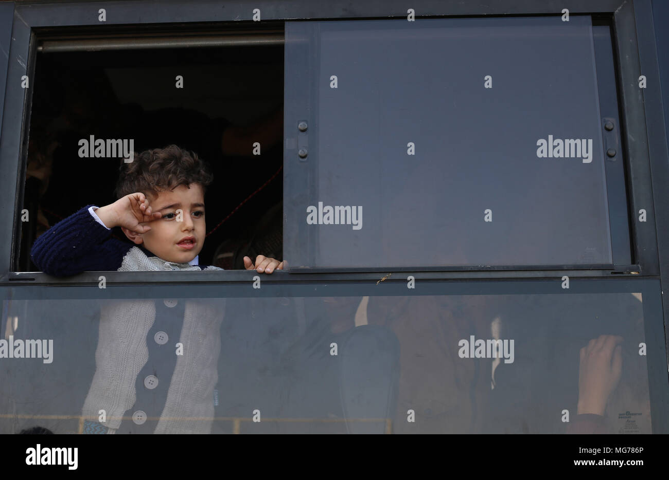 La striscia di Gaza. 28 apr, 2018. Un bambino palestinese guarda da una finestra di bus come egli attende di entrare in Egitto con la sua famiglia da Khan Younis, a sud della striscia di Gaza, il 28 aprile 2018. In Egitto il Sabato aperto il valico di Rafah al confine con i palestinesi nella striscia di Gaza in entrambe le direzioni e lascerebbe aperta per tre giorni. Credito: Khaled Omar/Xinhua/Alamy Live News Foto Stock