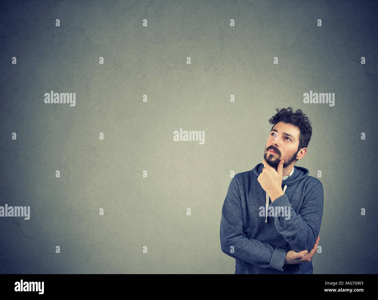 Ritratto di un uomo serio pensare guardando in alto isolato su sfondo a parete con copia spazio. Le emozioni umane, percezione Foto Stock