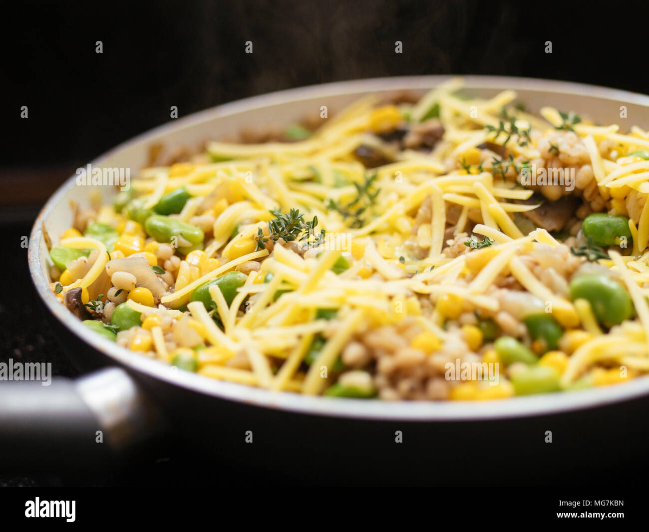 Orzo Risotto con fave, funghi e cucinare mais in una padella. Foto Stock