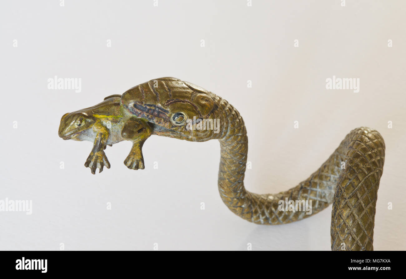 Verniciato a freddo Vienna / Austrian serpente di bronzo di mangiare una rana Foto Stock