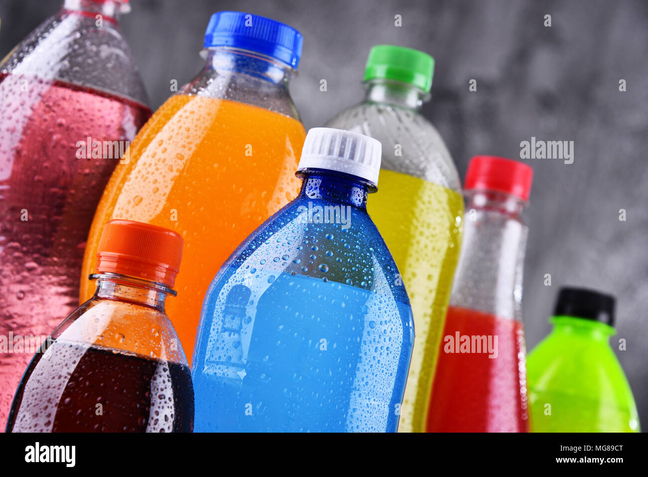 Le bottiglie di plastica di un assortimento di bevande analcoliche gassate in una varietà di colori Foto Stock