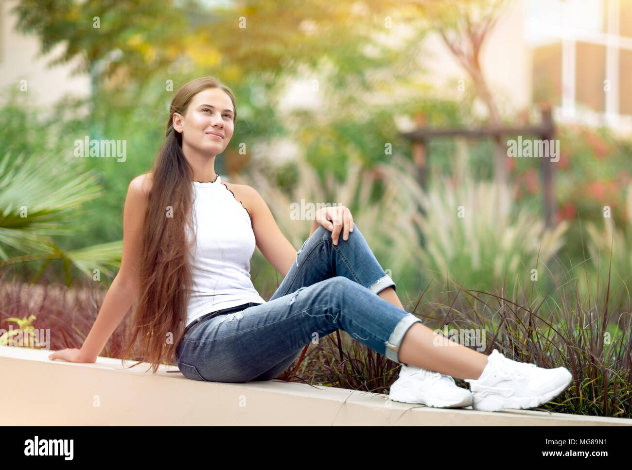 Ragazza sognante nel parco, bella donna seduta nel bellissimo giardino, godendo la freschezza della primavera la natura, con piacere trascorrere tranquille weekend al di fuori Foto Stock