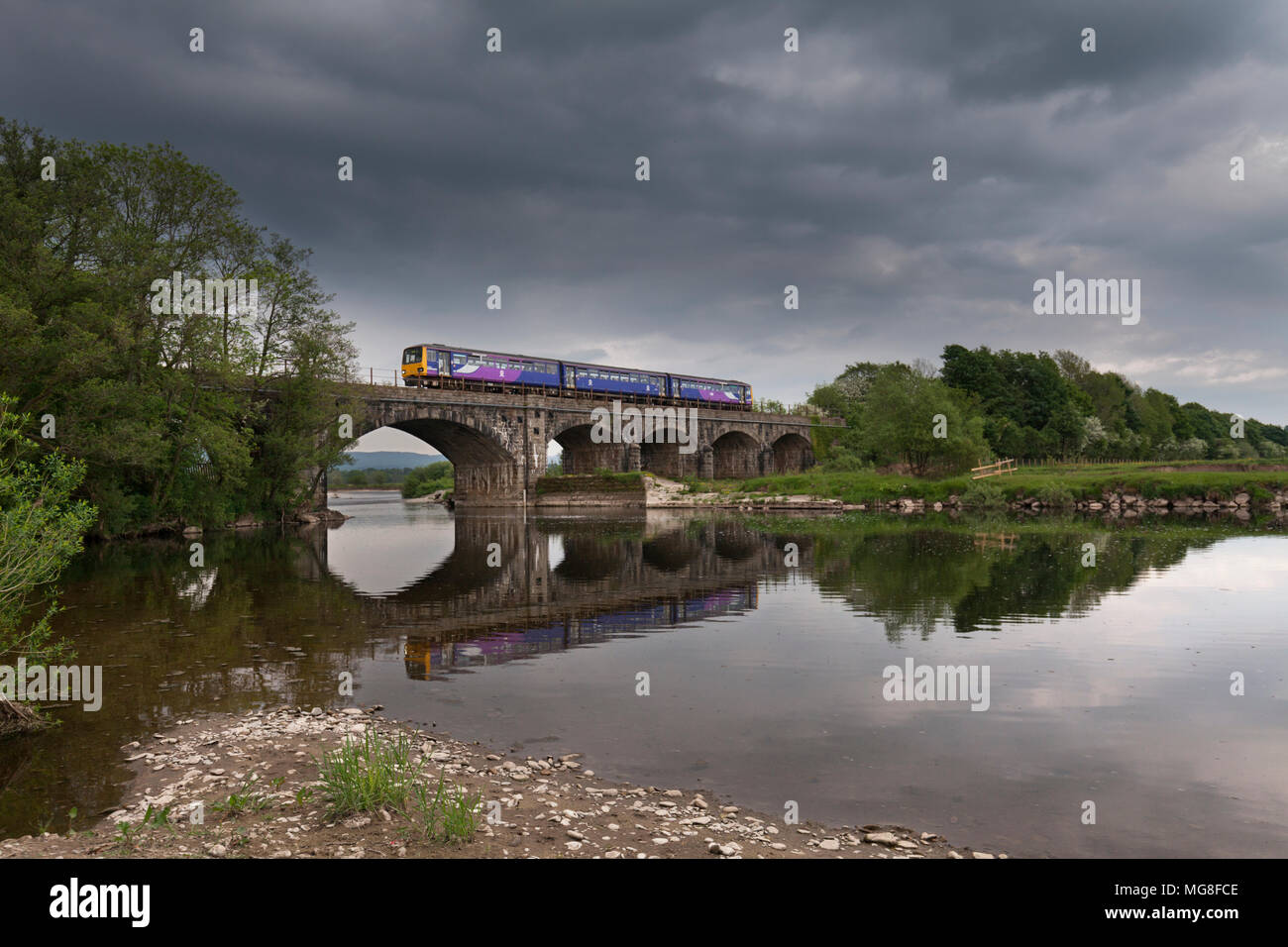 Un Arriva ferroviaria settentrionale classe 144 pacer treno attraversa il fiume Lune a Arkholme est di Carnforth Foto Stock