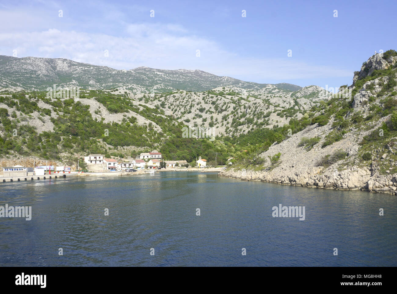 Prizna, Croazia, 24 aprile 2018. Piccolo villaggio Prizna, porto traghetti,  con vista mare e montagna di Velebit in background, nella tarda primavera  Foto stock - Alamy