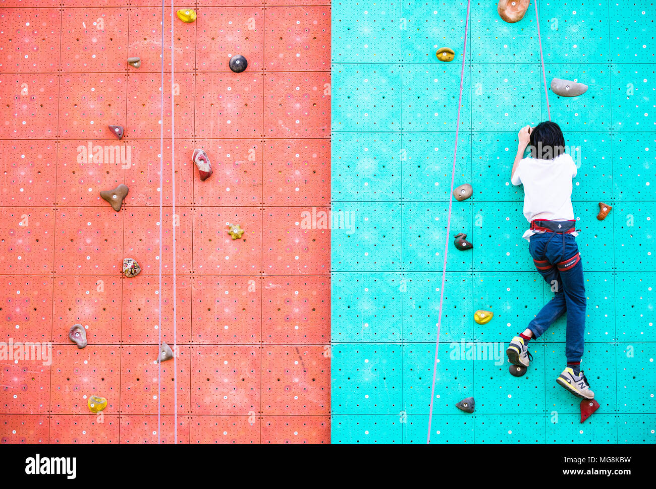 Roma, Italia, 25 aprile 2018. Ragazzo giovane arrampicata su parete artificiale di attività per il tempo libero durante la giornata della terra sport spazio nel parco all'aperto Foto Stock