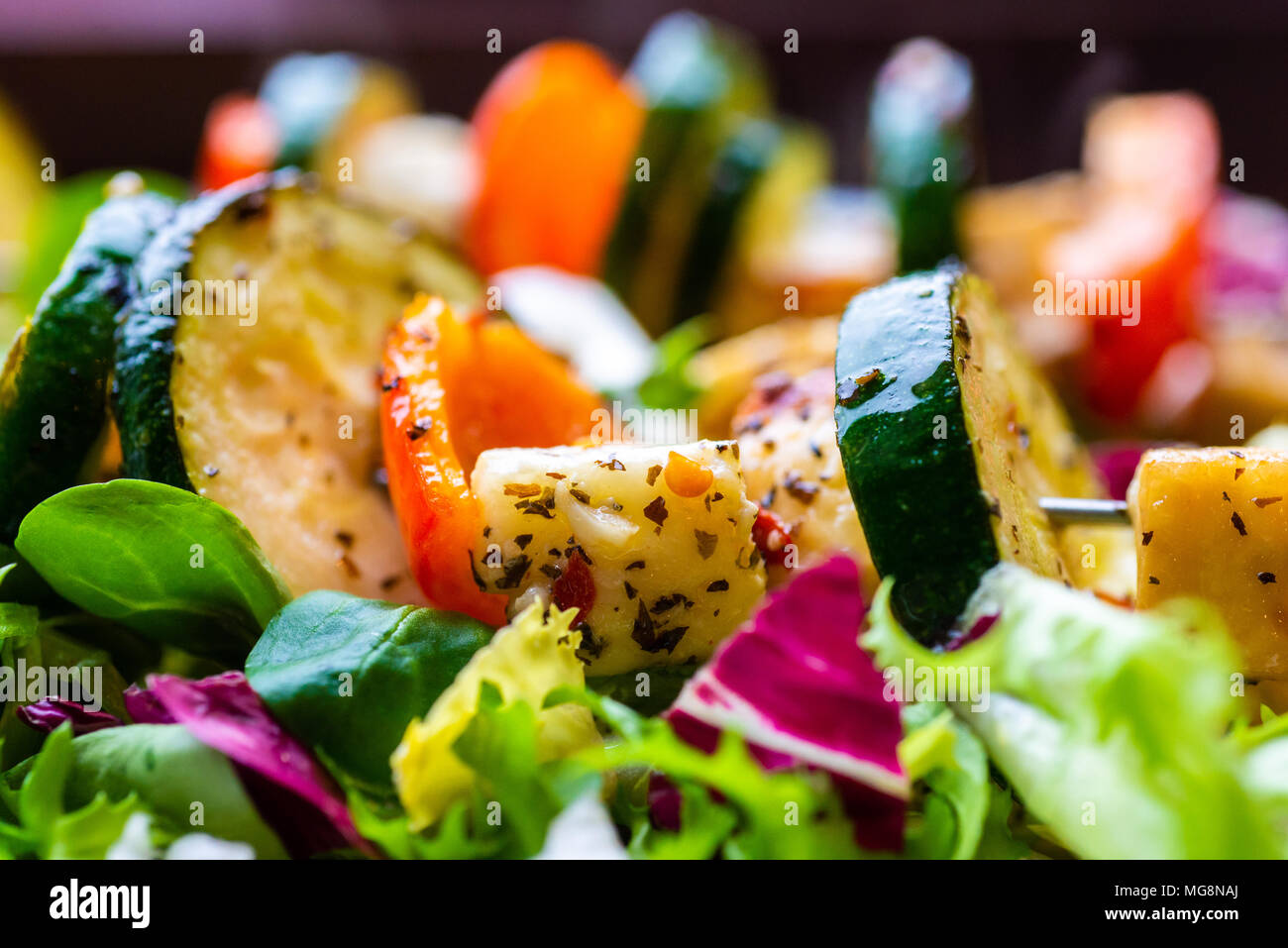 Halloumi, la zucchina, pepe rosso kebab servito su un letto di insalata, un sano pasto vegetariano. Foto Stock