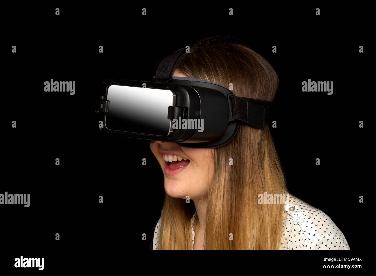 Giovane donna che indossa la realtà virtuale auricolare, studio shot. Foto Stock