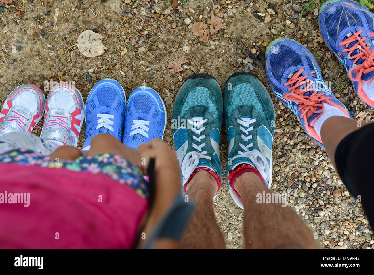 Piedi con scarpe di diverse dimensioni e colori prima di una famiglia di escursione, Mount Stuart sentieri escursionistici, Townsville, Queensland, Australia Foto Stock