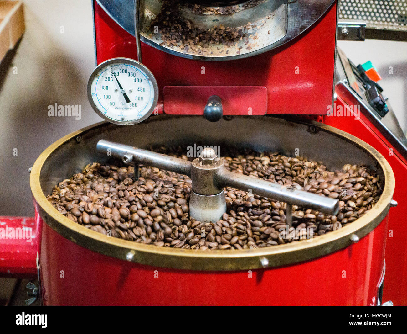Boquete, Panama, Dicembre 3, 2017 - i chicchi di caffè sono agitato dalla macchina come essi vengono cotti in preparazione per l'insacco Foto Stock