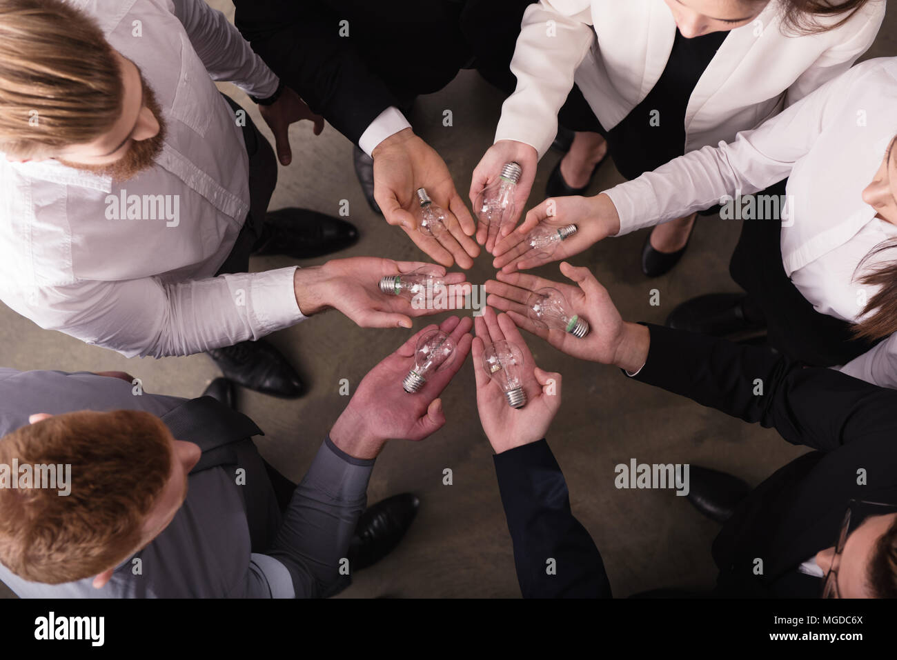 Il lavoro di squadra e il concetto di brainstorming con gli imprenditori che condividono un'idea con una lampada. Concetto di startup Foto Stock