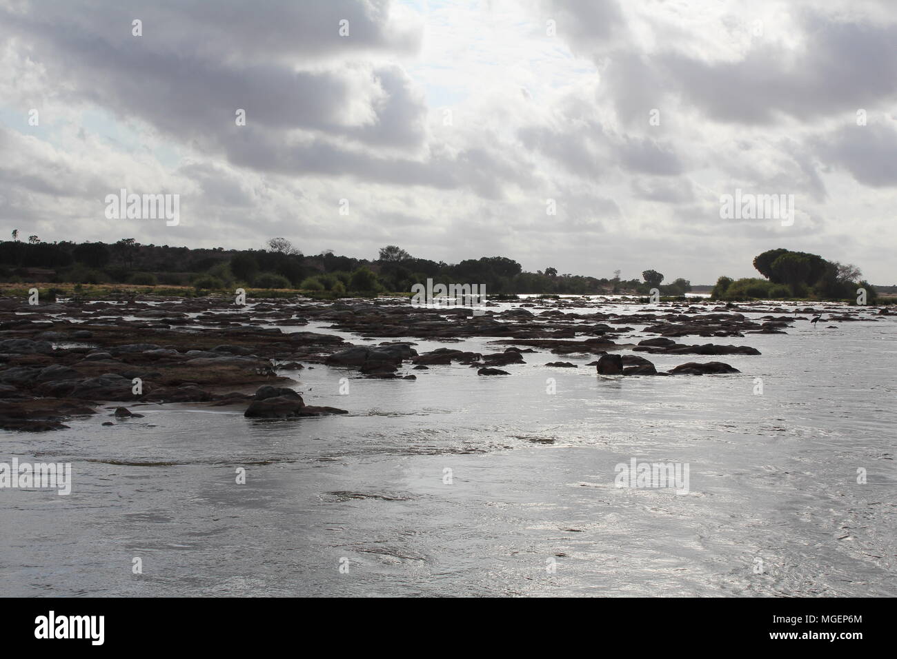 La Rocky River e un arido paesaggio dividere il Tsavo National Park in Kenya, Africa Foto Stock