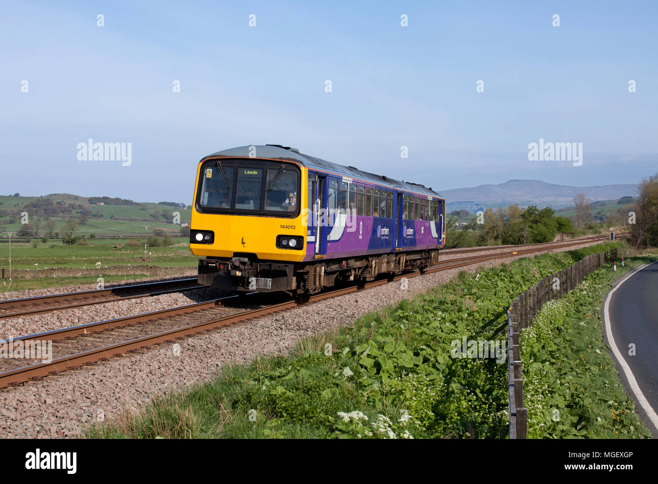 Una rampa settentrionale classe 144 treno dello stimolatore a Settle Junction, Yorkshire con un Lancaster al treno di Leeds Foto Stock