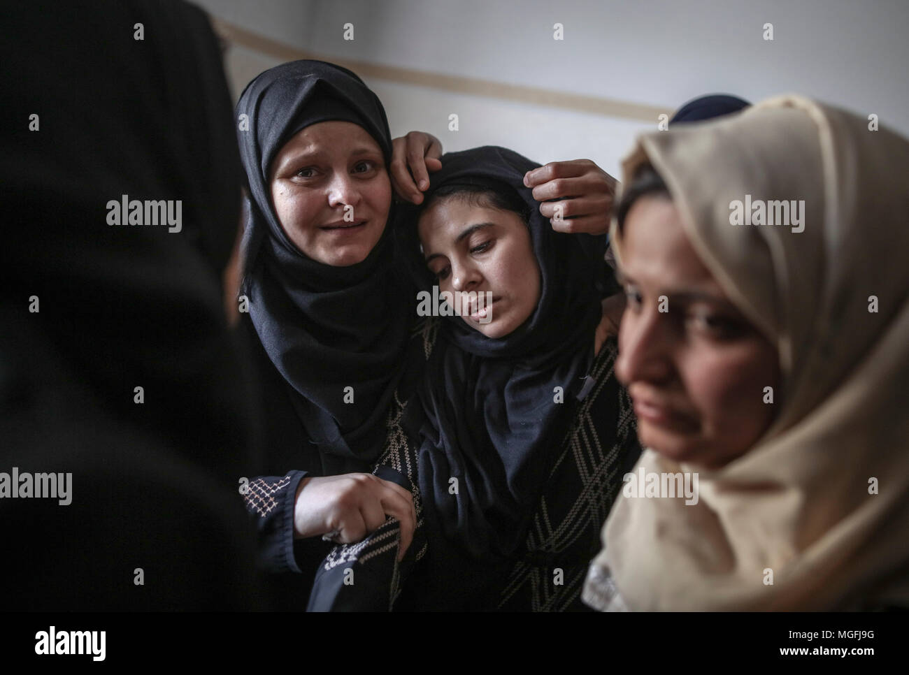 Khan Yunis, sud della striscia di Gaza. 28 apr, 2018. I parenti del palestinese Azam Ewidah, 15, che è stato ucciso durante gli scontri con forze di sicurezza israeliane al confine Israel-Gaza, piangono durante il suo funerale in Khan Yunis, sud della striscia di Gaza, 28 aprile 2018. Secondo la sanità palestinese funzionari, 45 persone, tra cui cinque bambini, era stato ucciso mentre almeno 5.500 sono stati feriti al Israel-Gaza degli scontri di confine poiché le proteste hanno avuto inizio il 30 marzo. Credito: Wissam Nassar/dpa/Alamy Live News Foto Stock