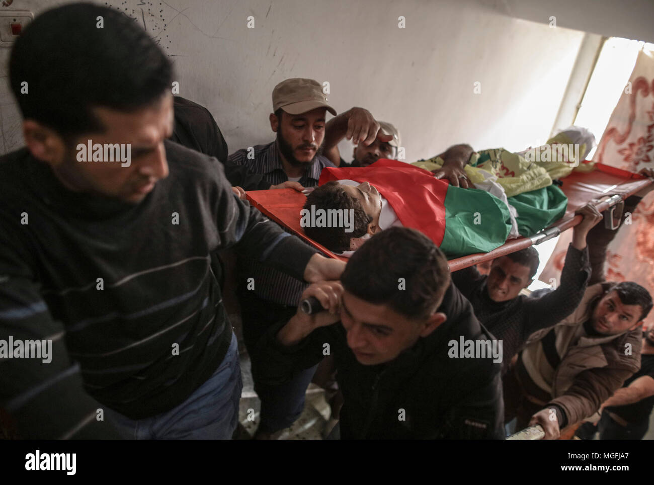 Khan Yunis, sud della striscia di Gaza. 28 apr, 2018. Persone in lutto portano il corpo del palestinese Azam Ewidah, 15, che è stato ucciso durante gli scontri con forze di sicurezza israeliane al confine Israel-Gaza, durante il suo funerale in Khan Yunis, sud della striscia di Gaza, 28 aprile 2018. Secondo la sanità palestinese funzionari, 45 persone, tra cui cinque bambini, era stato ucciso mentre almeno 5.500 sono stati feriti al Israel-Gaza degli scontri di confine poiché le proteste hanno avuto inizio il 30 marzo. Credito: Wissam Nassar/dpa/Alamy Live News Foto Stock