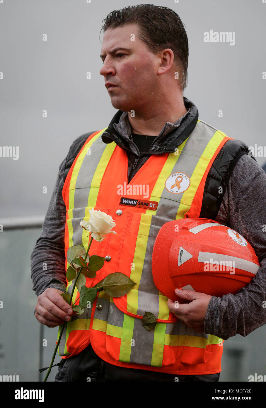 Vancouver, Canada. 28 apr, 2018. Un lavoratore tiene un fiore durante la giornata di lutto nazionale evento in Vancouver, Canada, 28 aprile 2018. Centinaia di persone hanno partecipato in Canada la giornata di lutto nazionale che viene osservato il 28 aprile per commemorare coloro che sono stati uccisi o feriti a causa del luogo di lavoro i rischi correlati e gli incidenti e aumentare la consapevolezza pubblica sulla sicurezza del lavoro. Credito: Liang Sen/Xinhua/Alamy Live News Foto Stock