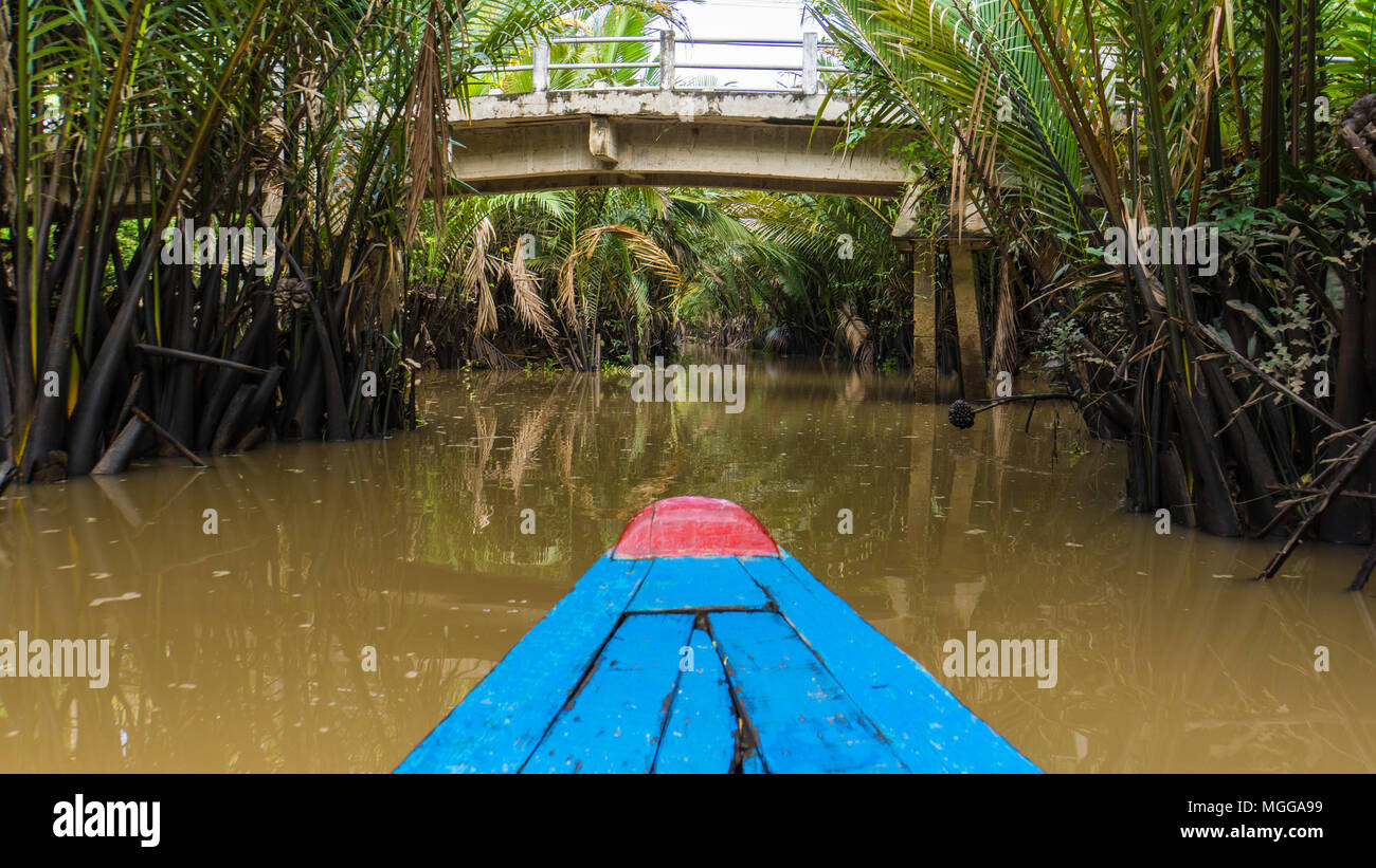 Avvicinando un ponte mentre passeggiate a cavallo nel Delta del Mekong in Vietnam in un sampan barca Foto Stock