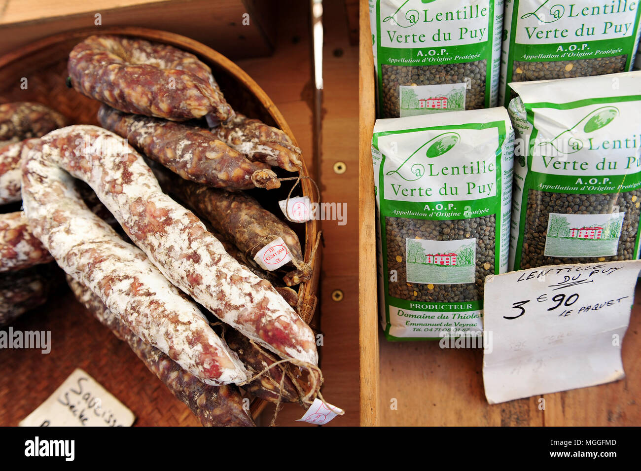 Sacchetti di Le Puy lenticchie verdi accanto ad alcuni prodotti localmente e salsicce presso il locale di frutta e verdura nel mercato della città di Le-Puy-en-Velay, Francia Foto Stock